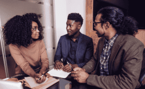 One woman and two men having a meeting.