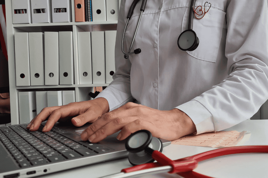 healthcare worker typing on keyboard