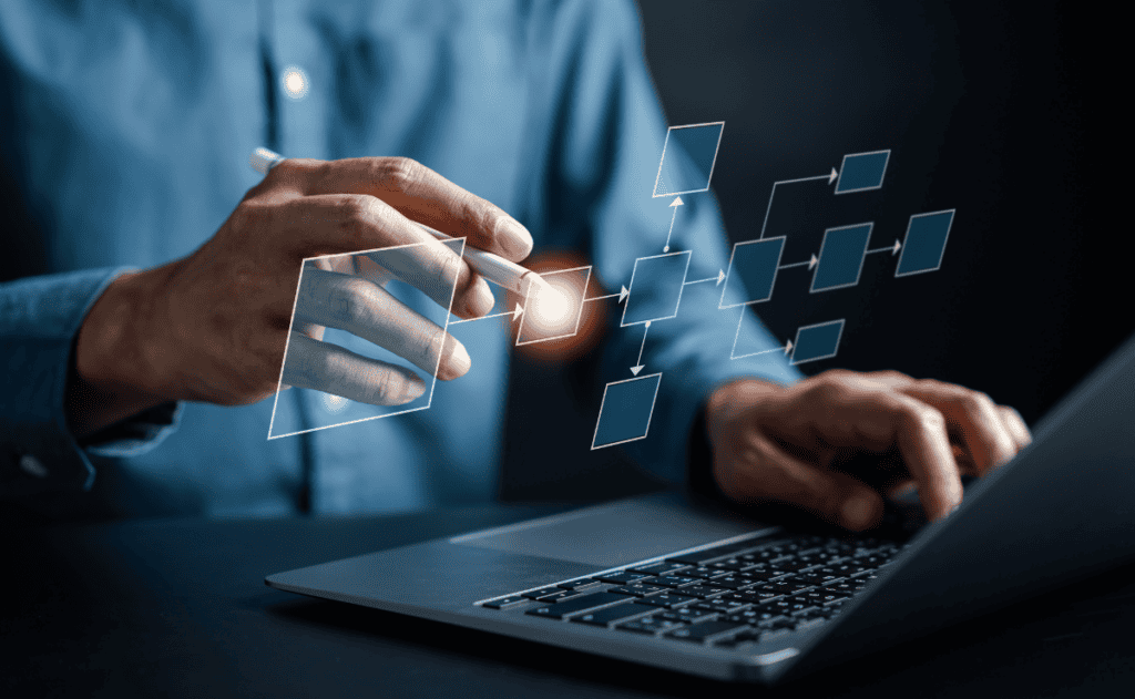 A man working on a laptop, viewing a diagram displayed on the screen.