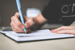 A person writing in a notebook.