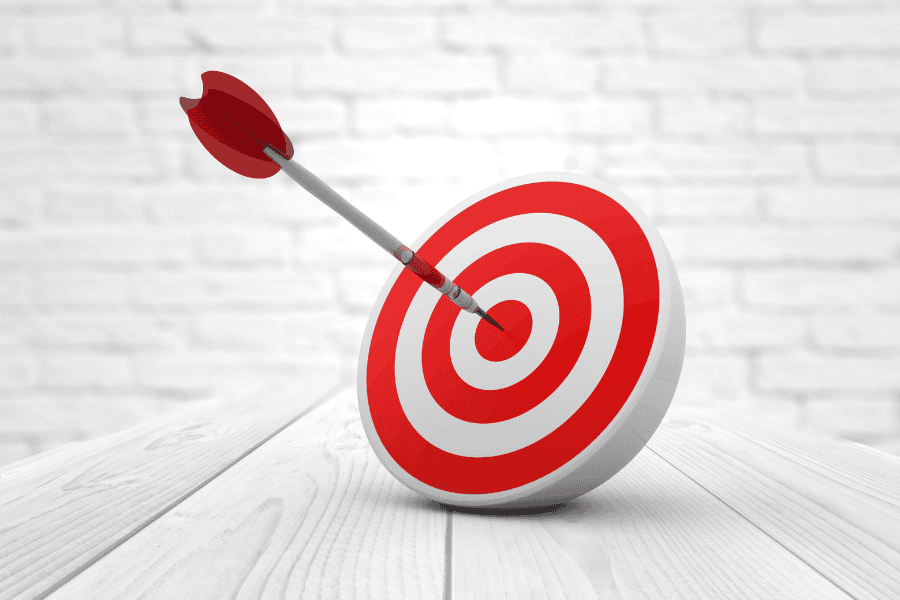 Red and white target on table with red dart in bullseye