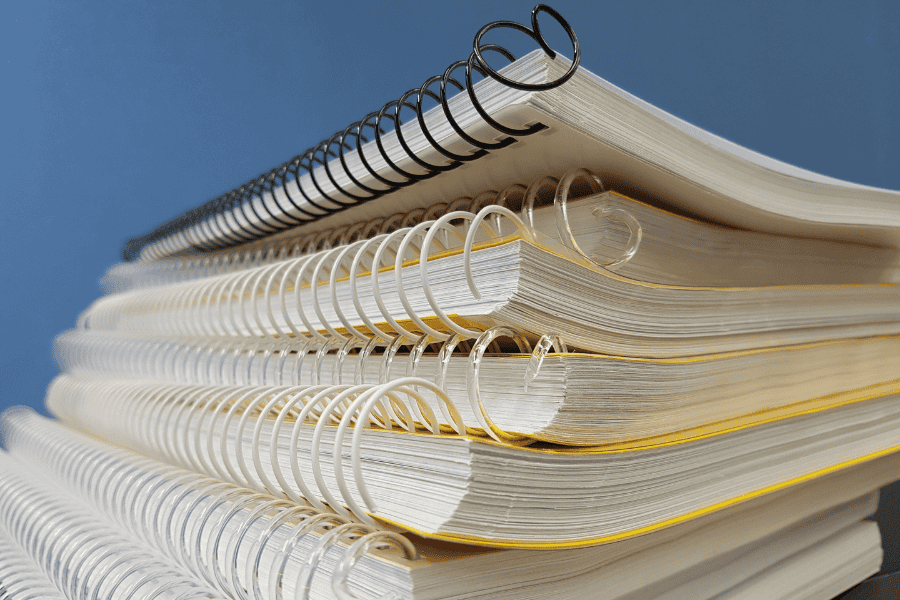 Close-up view of a stack of spiral-bound notebooks