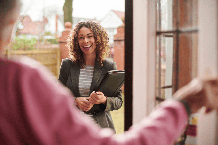 A woman engages in conversation with a resident in their home.