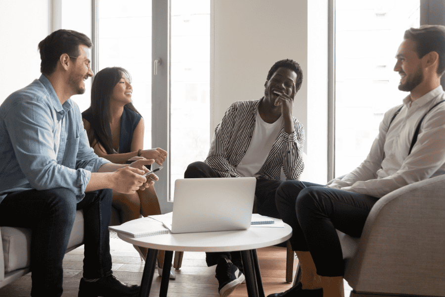 Four happy coworkers seated around a table.