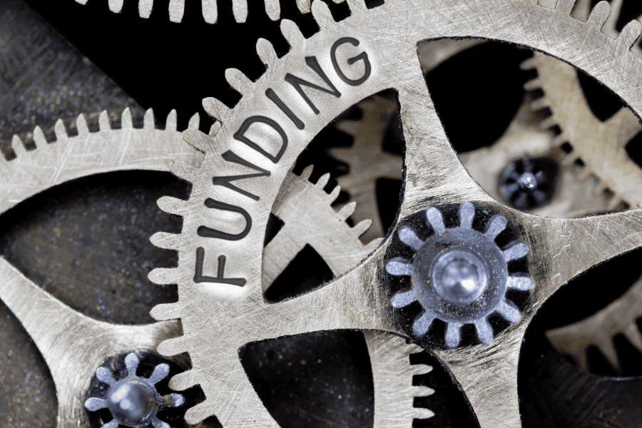 Image of gears. One of the gears has the word funding engraved on it.