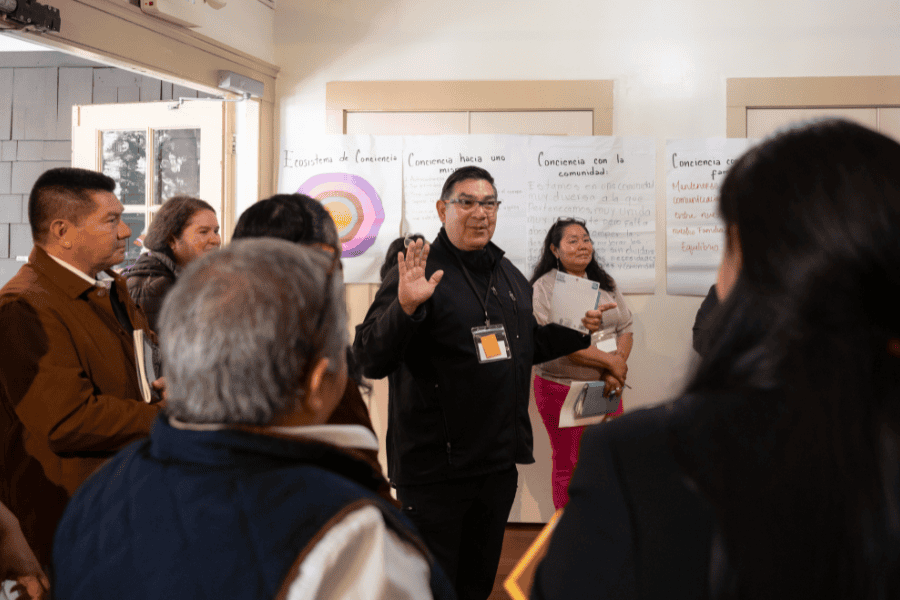 Attendee at Promotores Conference speaks in the center of a group.