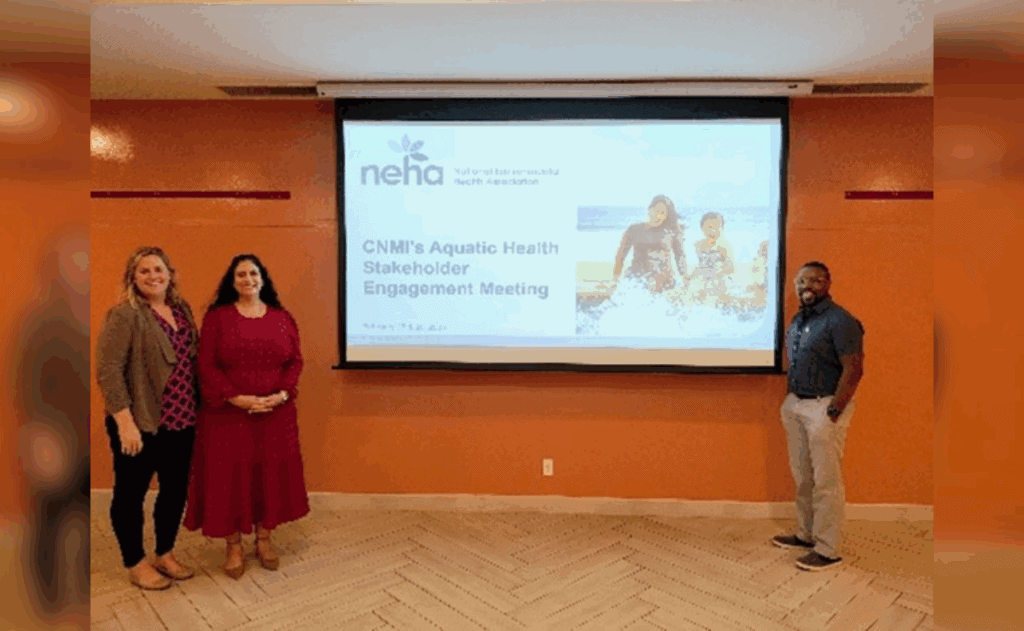 Three professionals standing in front of presentation on CNMI's Aquatic Health Stakeholder Engagement slides.