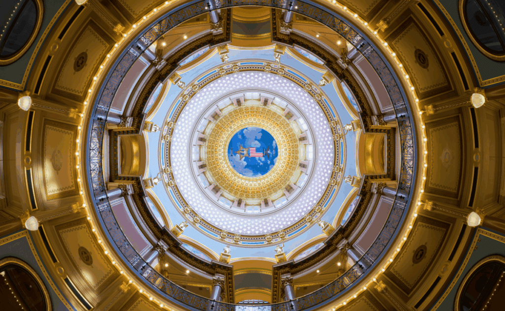 Image of a the inside of a buildings dome with symbols from the Iowa flag.
