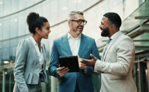 Three coworkers standing and talking in a huddle.
