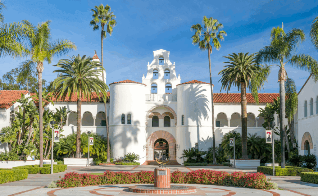 A white building with palm trees outfront belonging to San Diego State University.