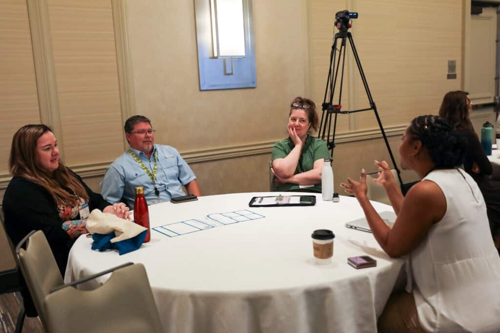Four individuals seated at a roundtable.