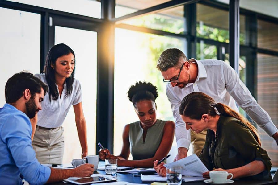 Businesspeople working together in modern office boardroom.